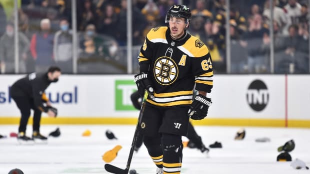 Jan 12, 2022; Boston, Massachusetts, USA; Boston Bruins left wing Brad Marchand (63) skates through a sea of hats after scoring his third goal of the game during the second period against the Montreal Canadiens at TD Garden. Mandatory Credit: Bob DeChiara-USA TODAY Sports